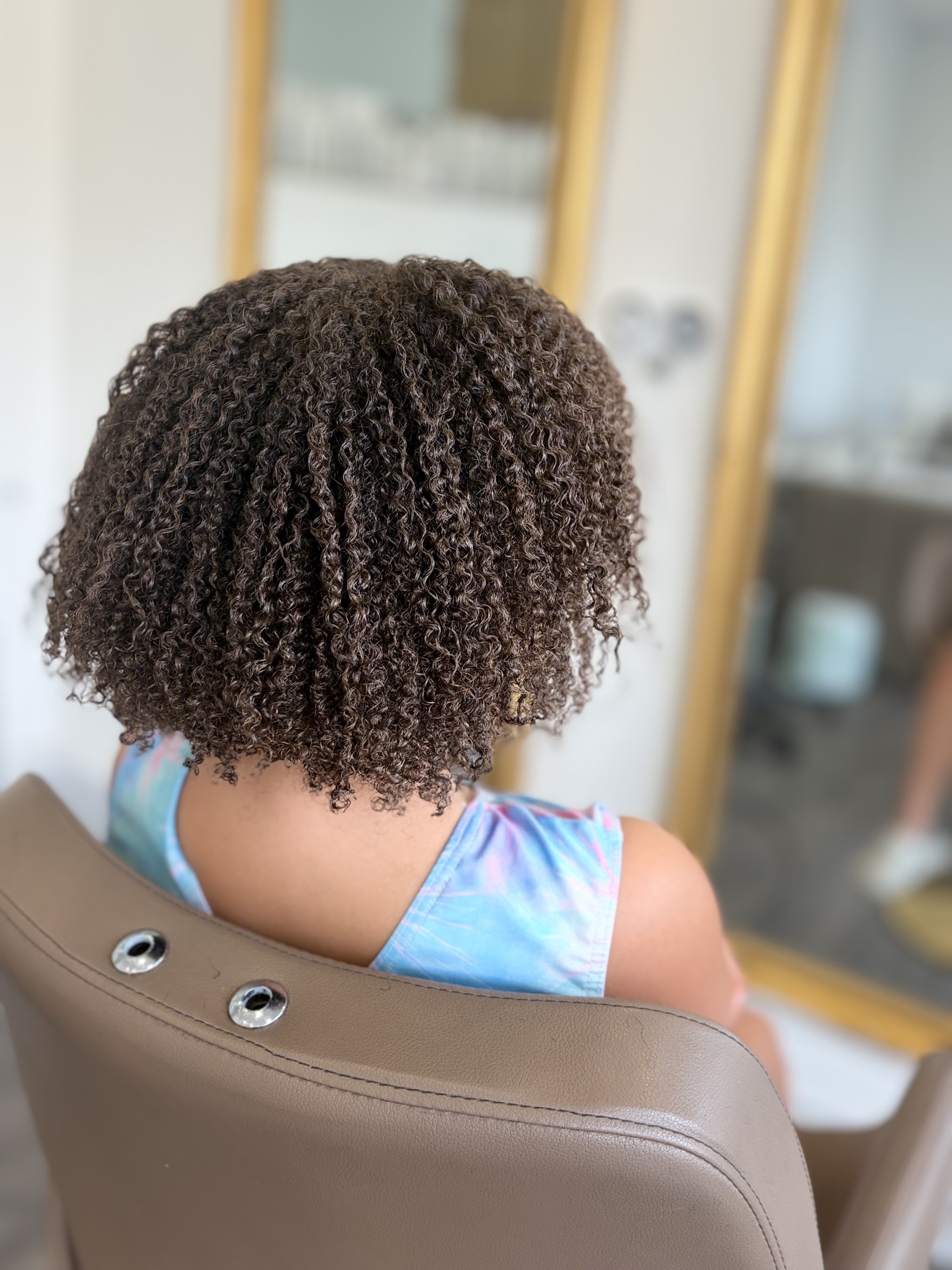 Defined natural curls photographed from behind in the salon